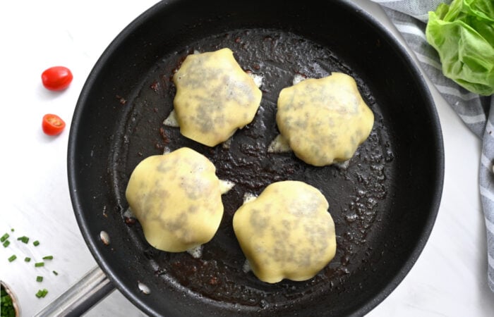 adding cheese to a smash burger