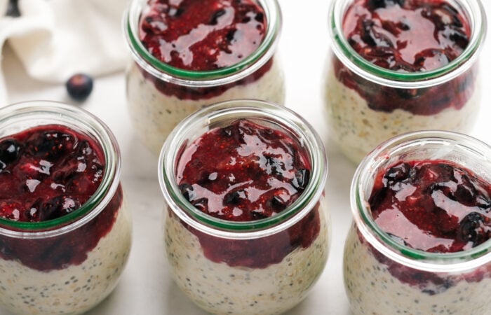 making jars of Blueberry Cheesecake Overnight Oats