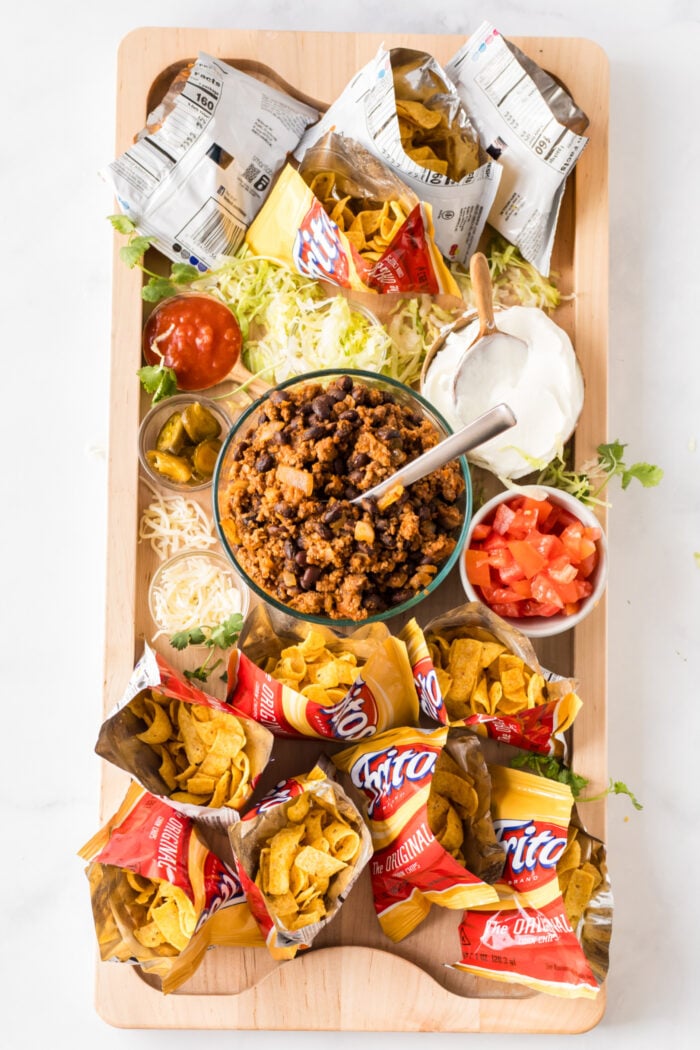 A board filled with Walking Tacos ingredients With Fritos