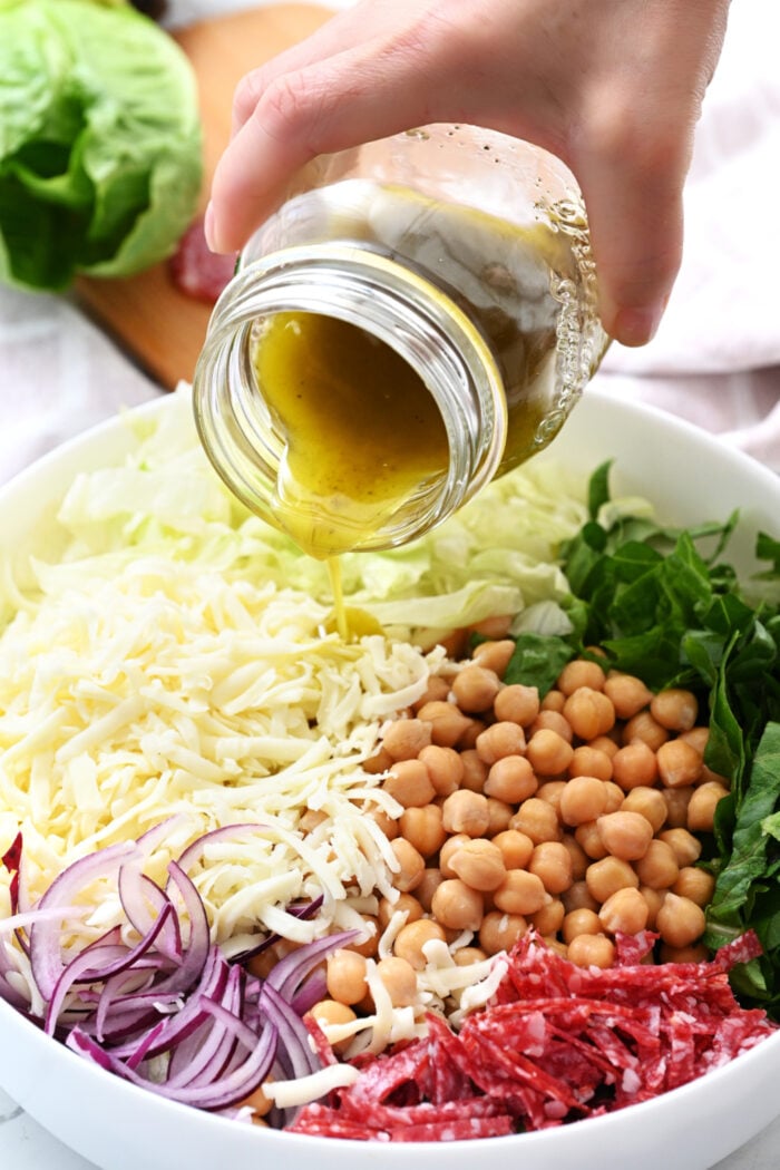 pouring dressing over La Scala Chopped Salad