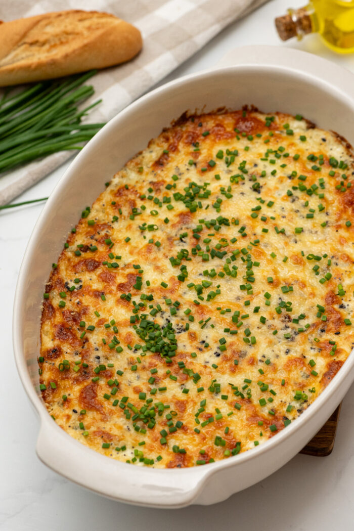 a big pan of garlic dip with melted cheese on top