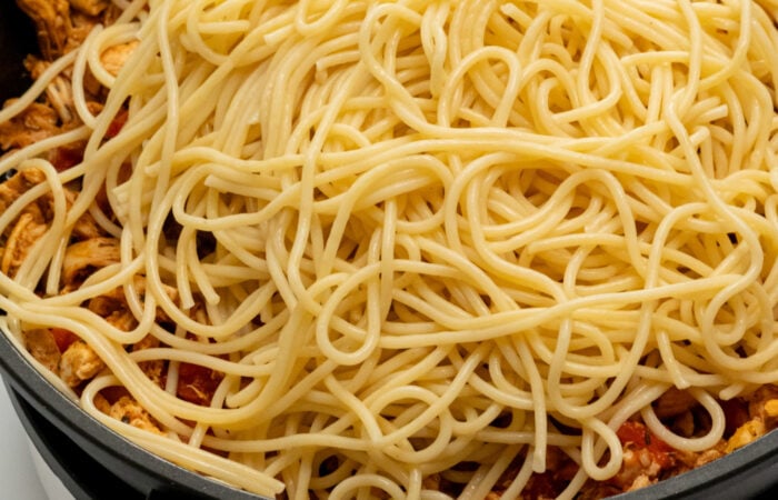 adding spaghetti to chicken