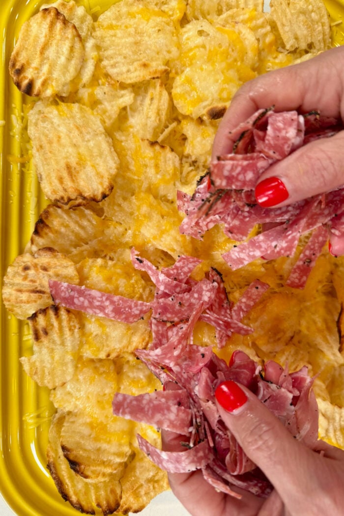 spreading out salami on chips