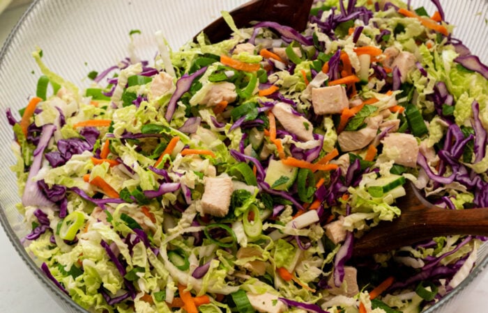 mixing a cabbage salad with chicken