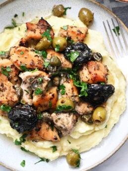 a serving of chicken on mashed potatoes