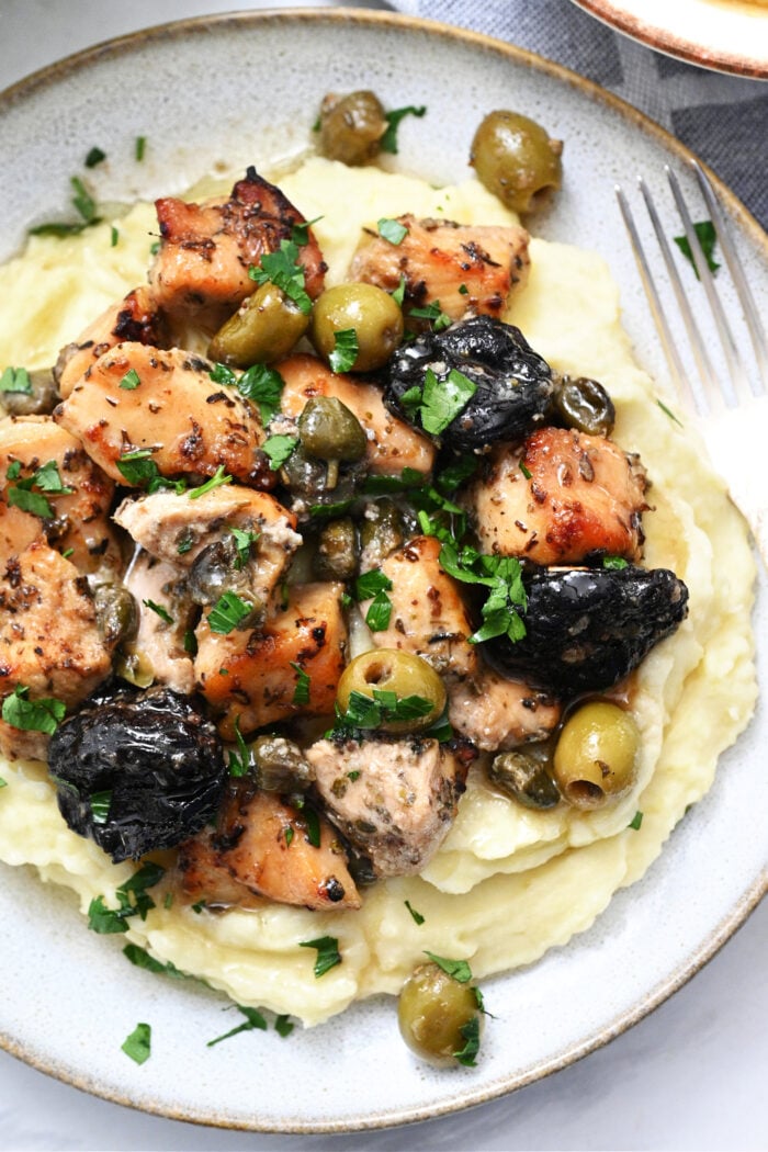 a serving of chicken on mashed potatoes