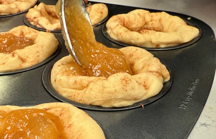 adding apple filling to cinnamon roll