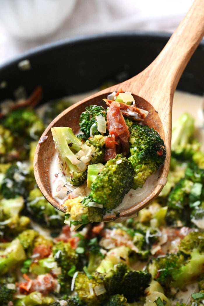 a spoonful of broccoli with sun dried tomatoes