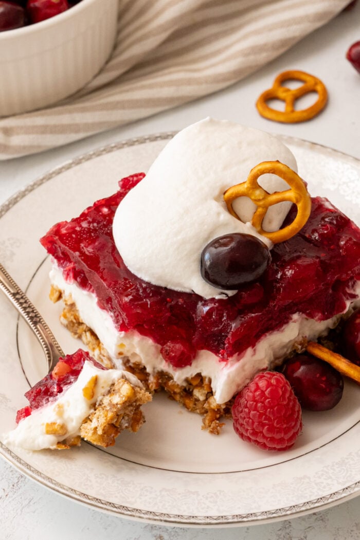 taking a bite of Cranberry Pretzel Salad with whipped cream