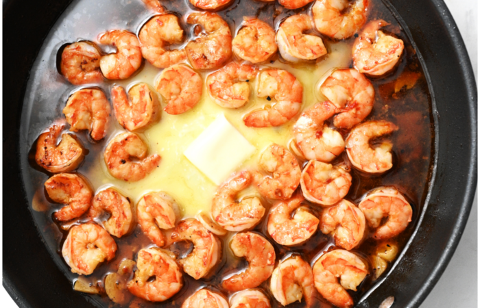 adding butter to shrimp dish