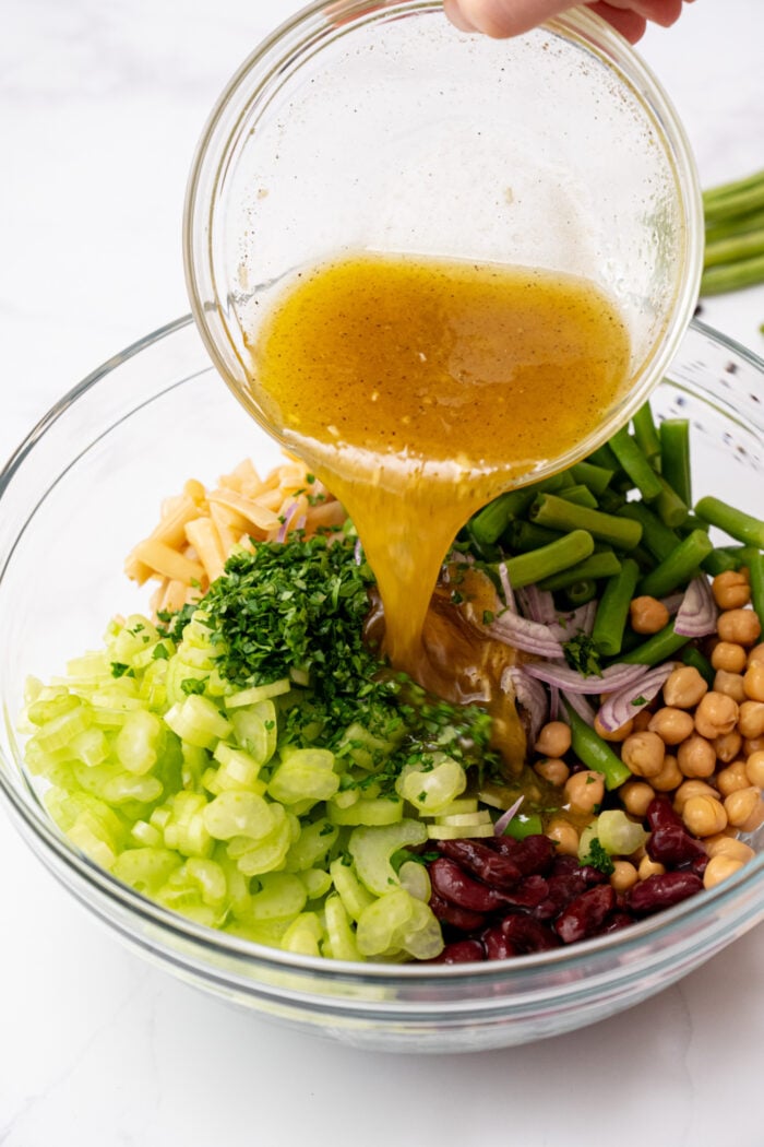 pouring dressing over a salad