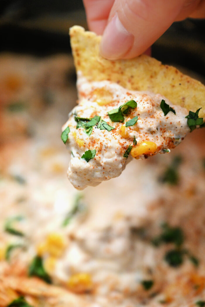 a bite of corn dip with a chip