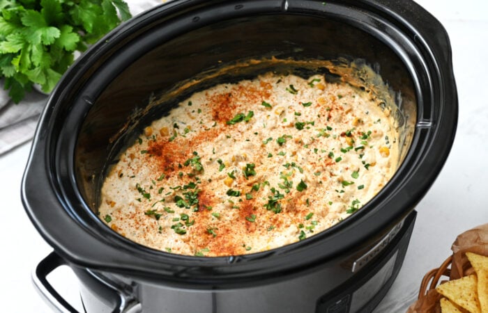 a crock pot filled with hot corn cheesy dip