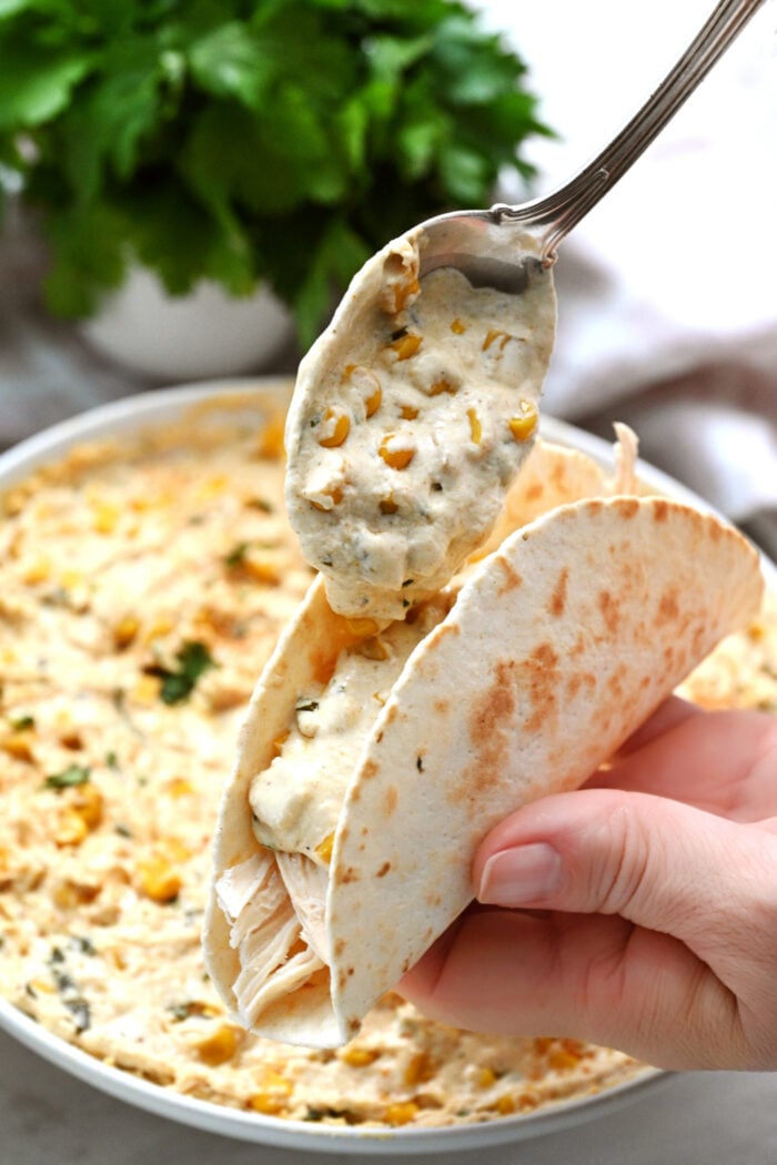 adding corn dip to a taco