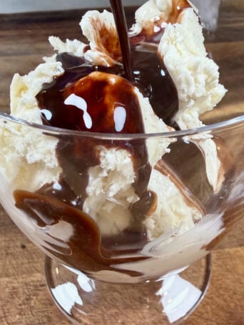 adding chocolate sauce to ice cream