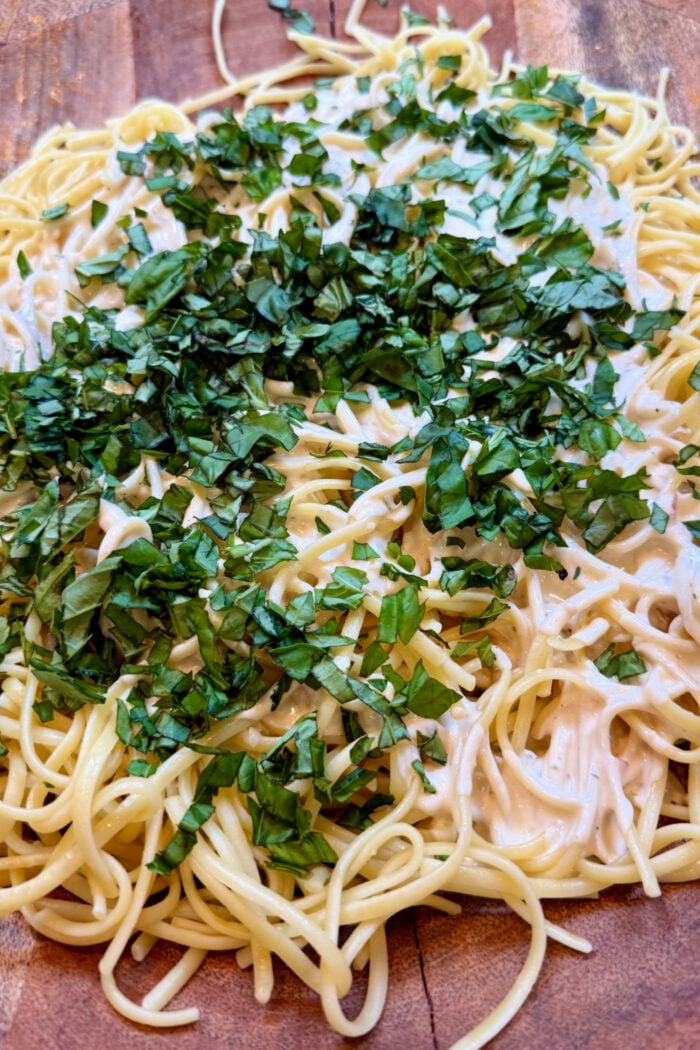 adding fresh basil to pasta