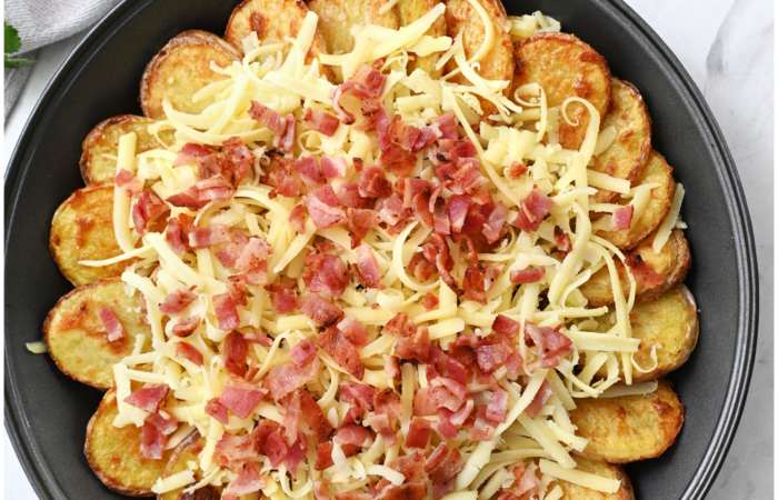 adding cheese and bacon to potatoes