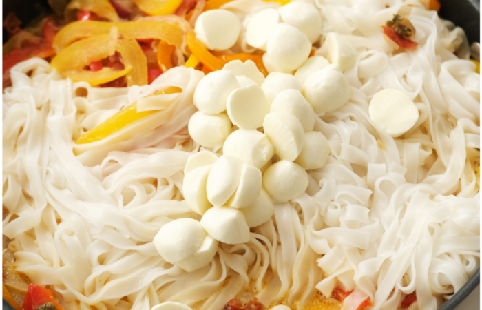 adding mozzarella cheese to noodles