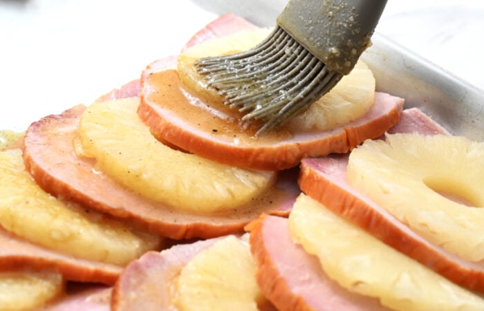 adding glaze to ham and pineapple