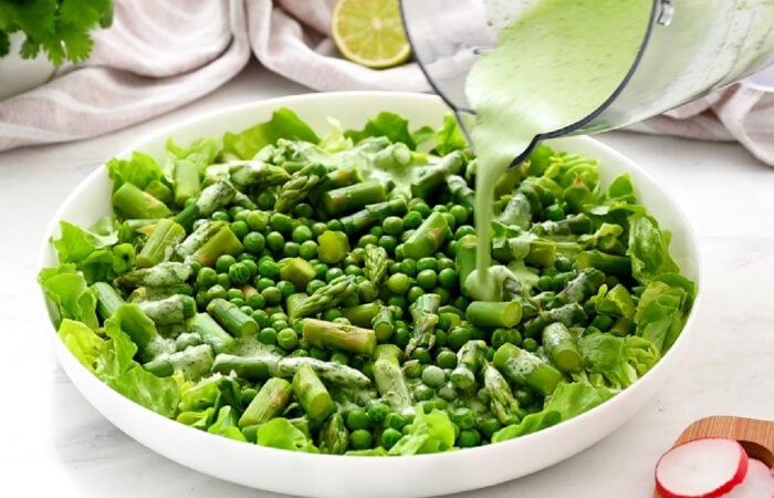 adding the dressing to the pea salad