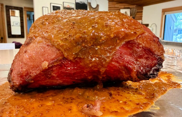 pouring mustard on a beef brisket