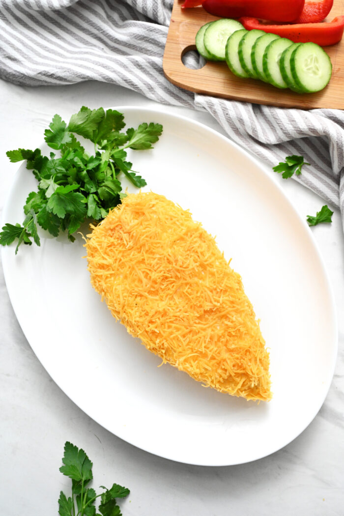 adding shredded cheese and fresh cilantro to cheese ball