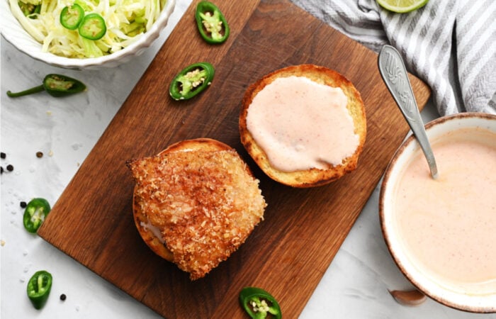 adding sauce to buns for fish burgers