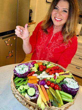 woman serving a Cottage Cheese Ranch Dip on veggies board