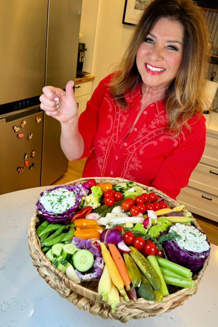 woman serving a Cottage Cheese Ranch Dip on veggies board