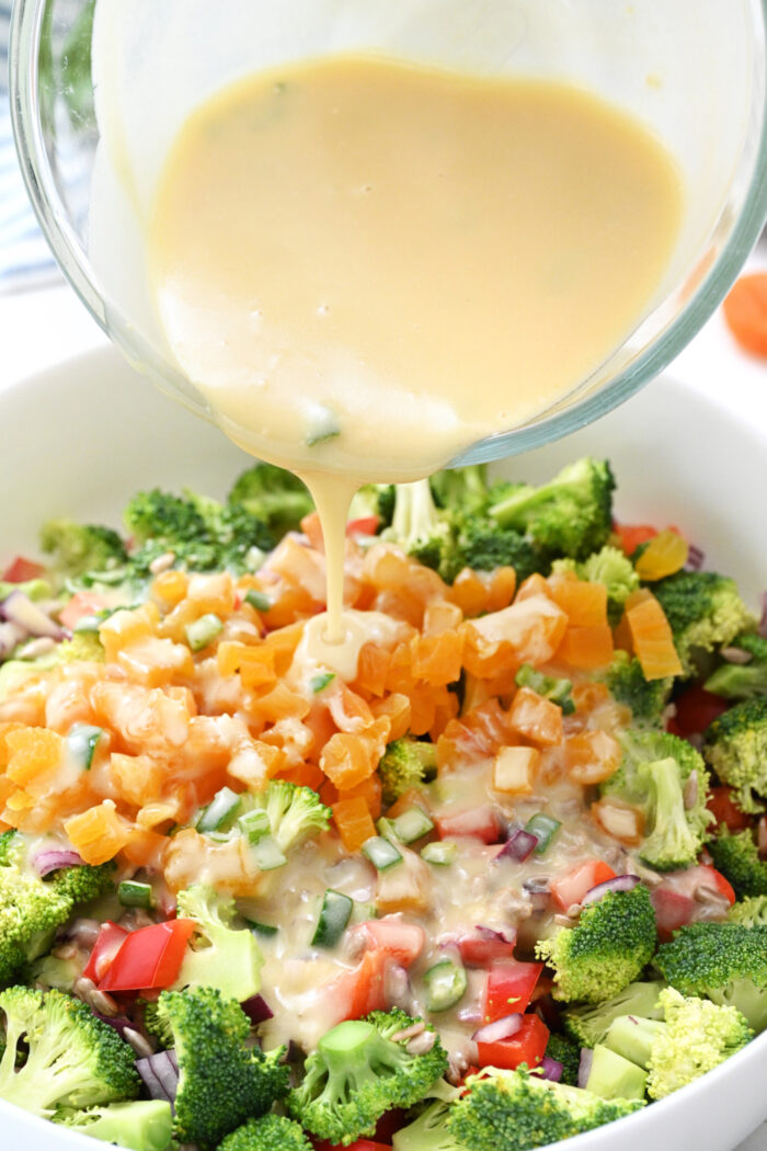 pouring dressing on a Sunflower Crunch Salad