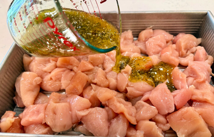 pouring marinade over chicken
