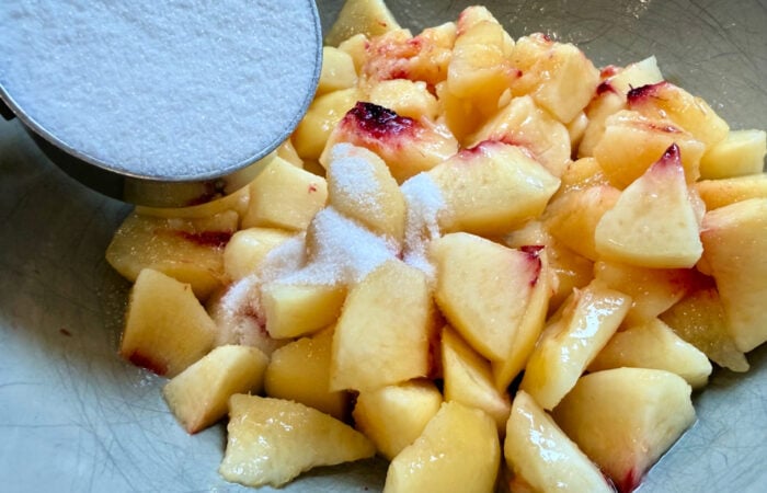 adding sugar to peaches