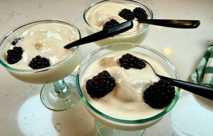 serving peach ice cream with blackberries