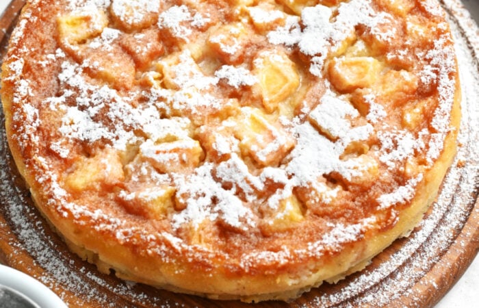 adding powdered sugar to a cake
