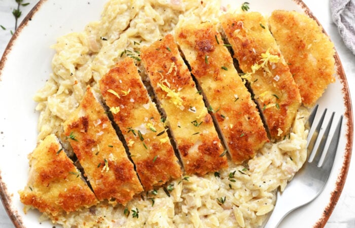 sliced crispy chicken on lemon orzo