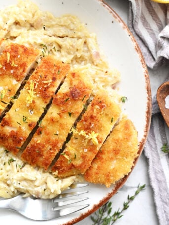 serving sliced crispy chicken with orzo
