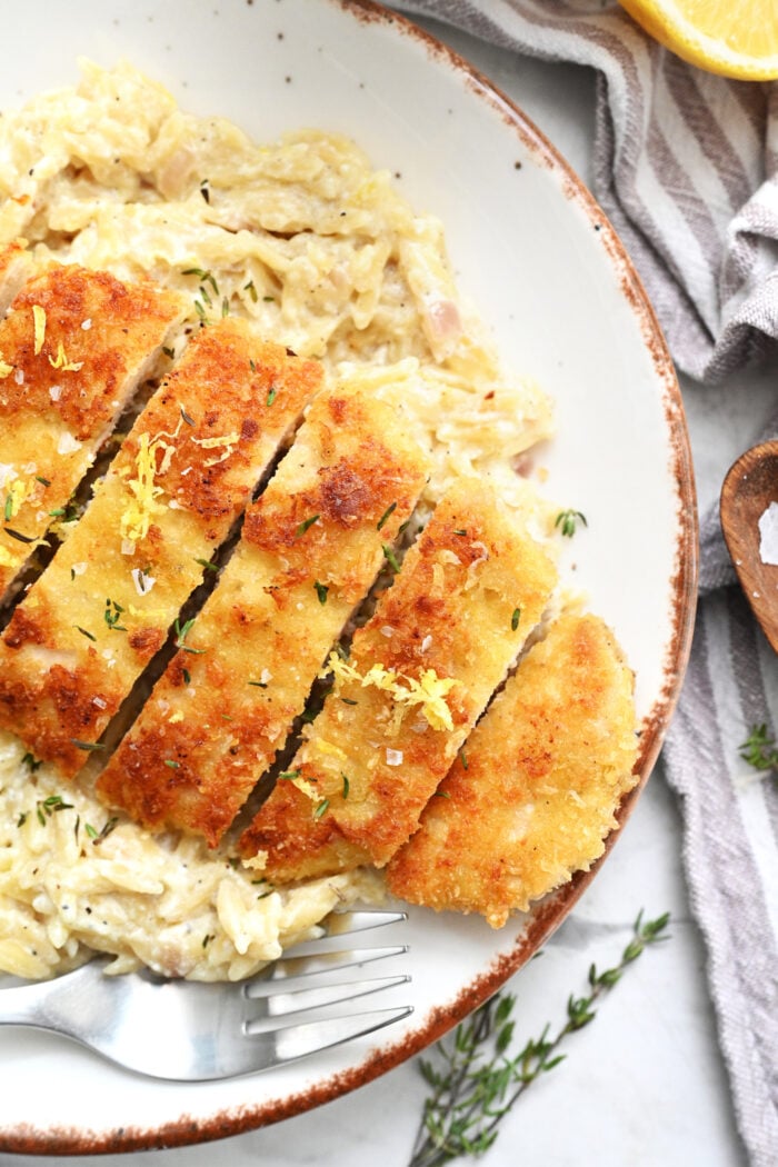 serving sliced crispy chicken with orzo